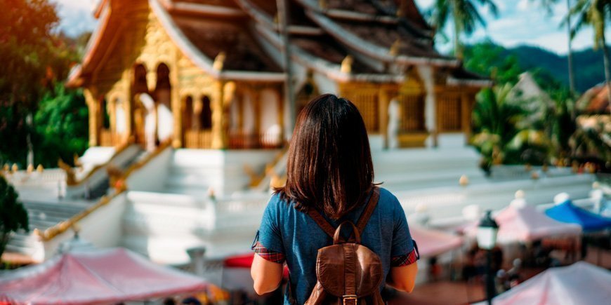 Kvinna tittar på tempel i Luang Prabang, Laos